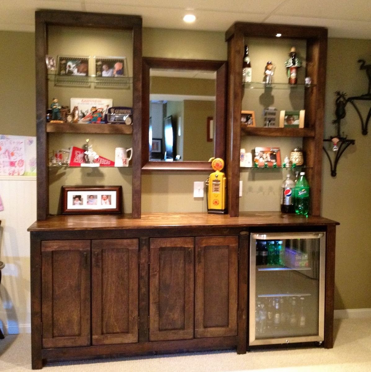 Basement bar with cabinets and glass shelves.