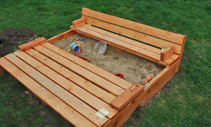 photo of stained wood sandbox with fold over cover that converts to seats